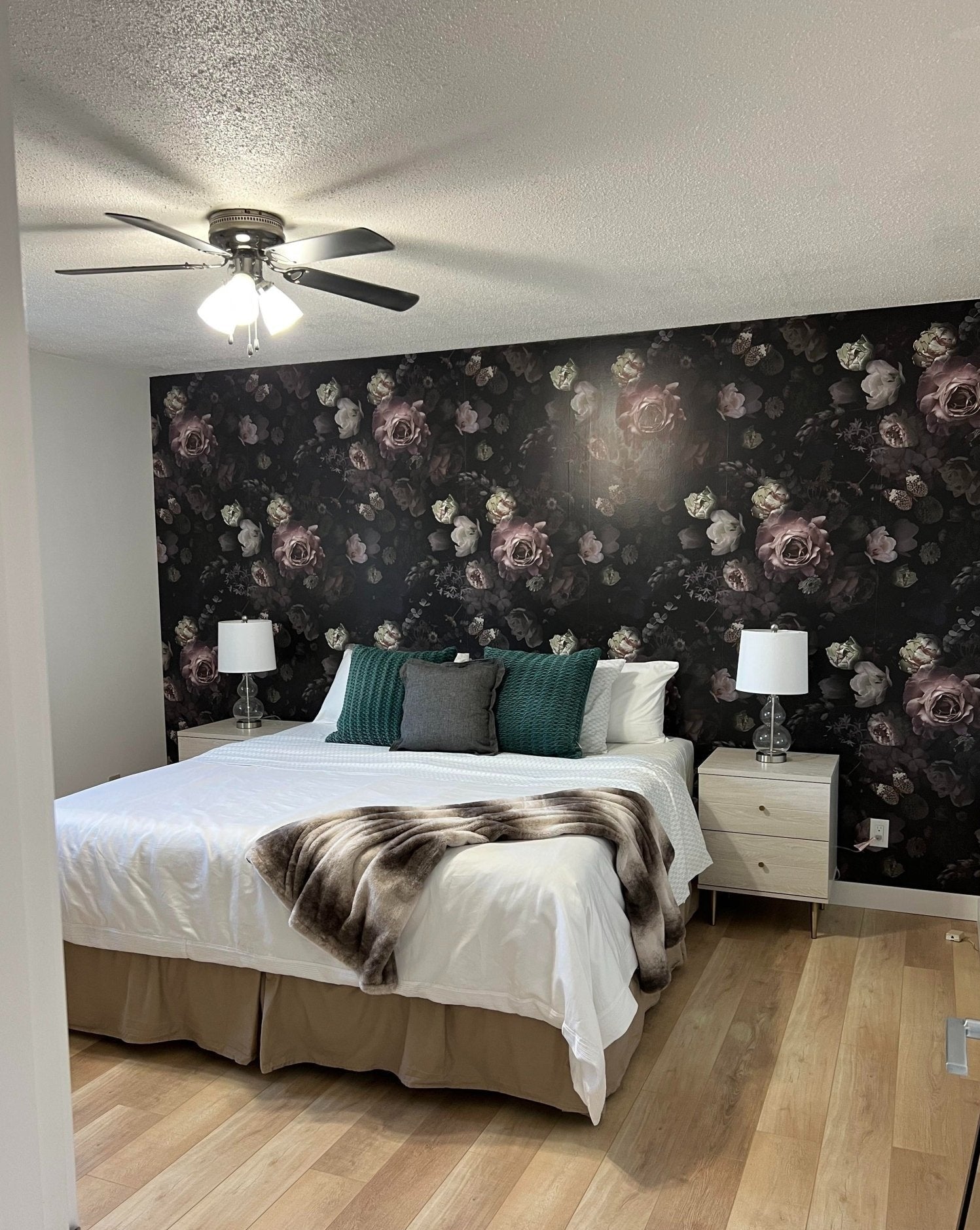 A bedroom with a ceiling fan and a bed Description automatically generated