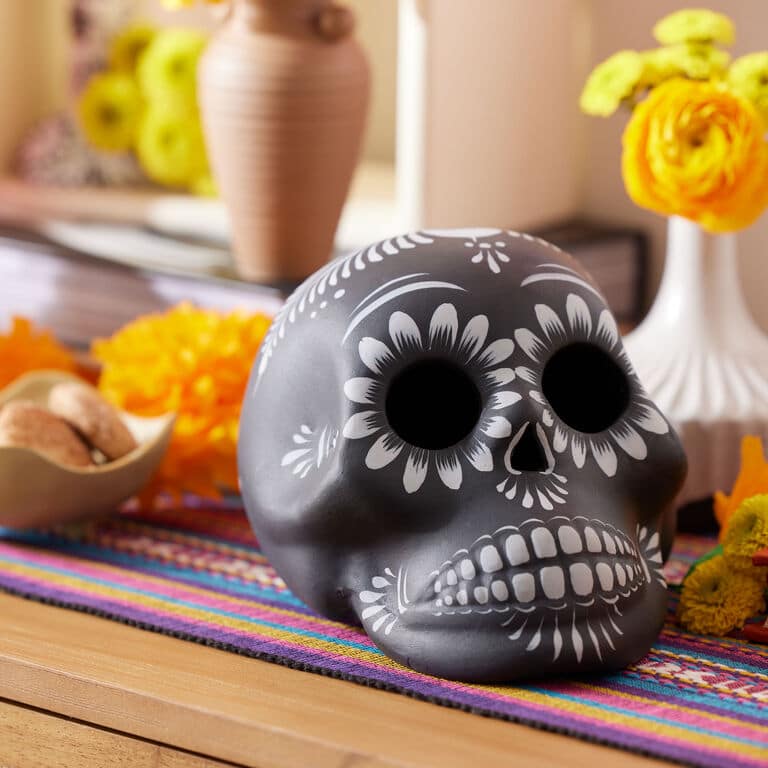 A hand-painted skull and skeletons placed on a table.