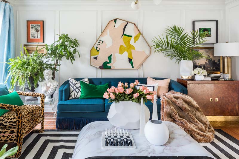 A vibrant living room with blue furniture and a zebra rug