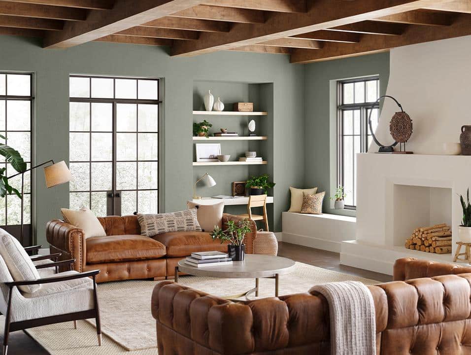 A cozy living room with a fireplace, leather furniture, and a rug, showcasing Sherwin Williams' Top Earthy Boho Colors