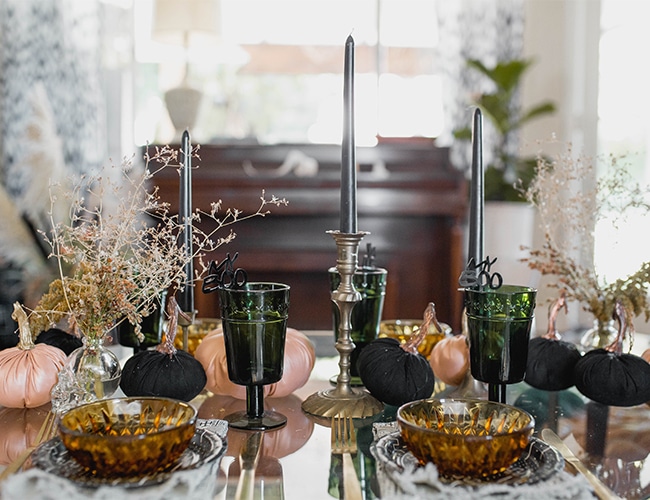 A table adorned with black and gold decorations and pumpkins, showcasing the uniqueness of Boho Halloween decor
